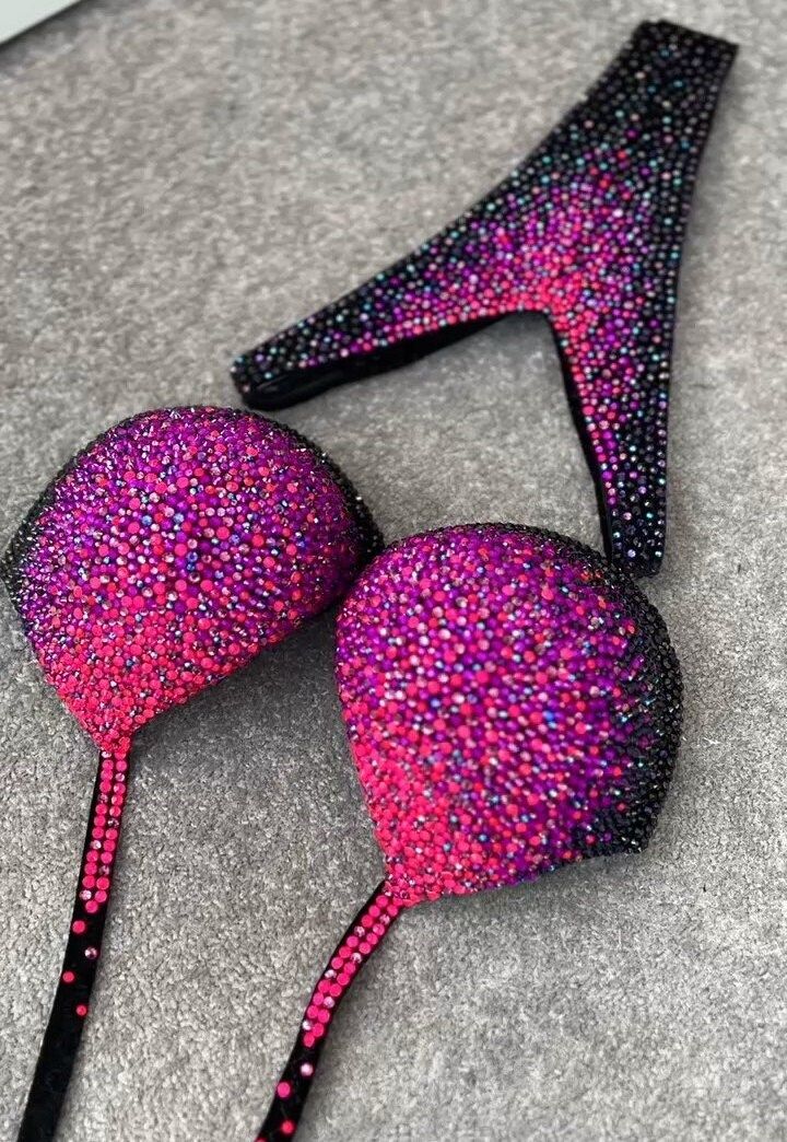 This bikini dazzles with a combination of sparkling black, deep purple, and neon pink rhinestones, creating a vibrant and eye-catching ensemble. The bold and vivid colors of the rhinestones contrast beautifully with the rich black fabric, making it a striking swimwear choice. Production time excluding delivery: finished design - 4-5 weeks; custom design 2-3 months. ----------------------------------------------------- We invite you to see other offers of our store. Pink Shining Crystals Fitness Bride Basket, Lilac Fairy, Brides Basket, Figure Competition, Womens Sports, Shape Wear, Fabric Making, Pink Rhinestones, Romantic Style