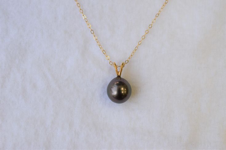 PLEASE CHECK OUR SHOP ANNOUNCEMENTS FOR PROCESSING TIMES :) The size of the Tahitian black pearl is approximately 10x10.5mm. The pearl is slightly teardrop shape. It has slightly dark gray overtones and high luster and minor blemishes. The rabbit ear finding and the chain is in 14K yellow gold. The total length of the pendant is approximately 5/8 inches long. Please visit our shop policies for more details! We only use real pearls in all of our jewerly. For more information, Like us on Facebook, Tahitian Pearl Necklace For Wedding, Black Pearl Necklace With High Luster For Gift, Black Tahitian Pearl Jewelry For Anniversary, Anniversary Black Tahitian Pearl Jewelry, Black Pearl Pendant, Tahitian Black Pearls, Freshwater Pearl Ring, Gold Birthday, Real Pearls