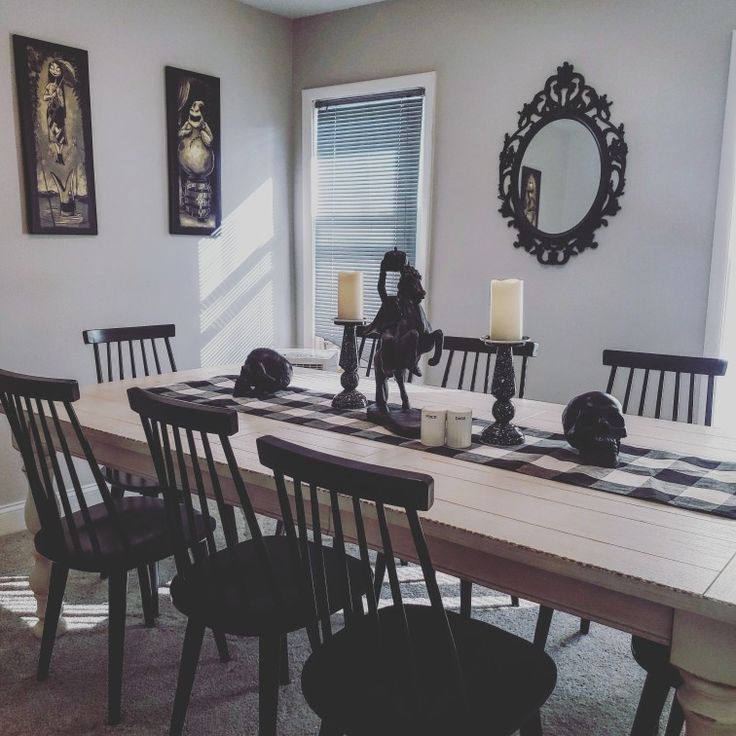 a dining room table with black chairs and a checkered table cloth on the table