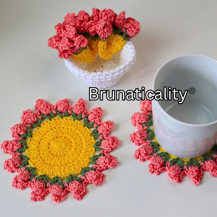 three crocheted coasters with flowers on them and a coffee cup in the middle