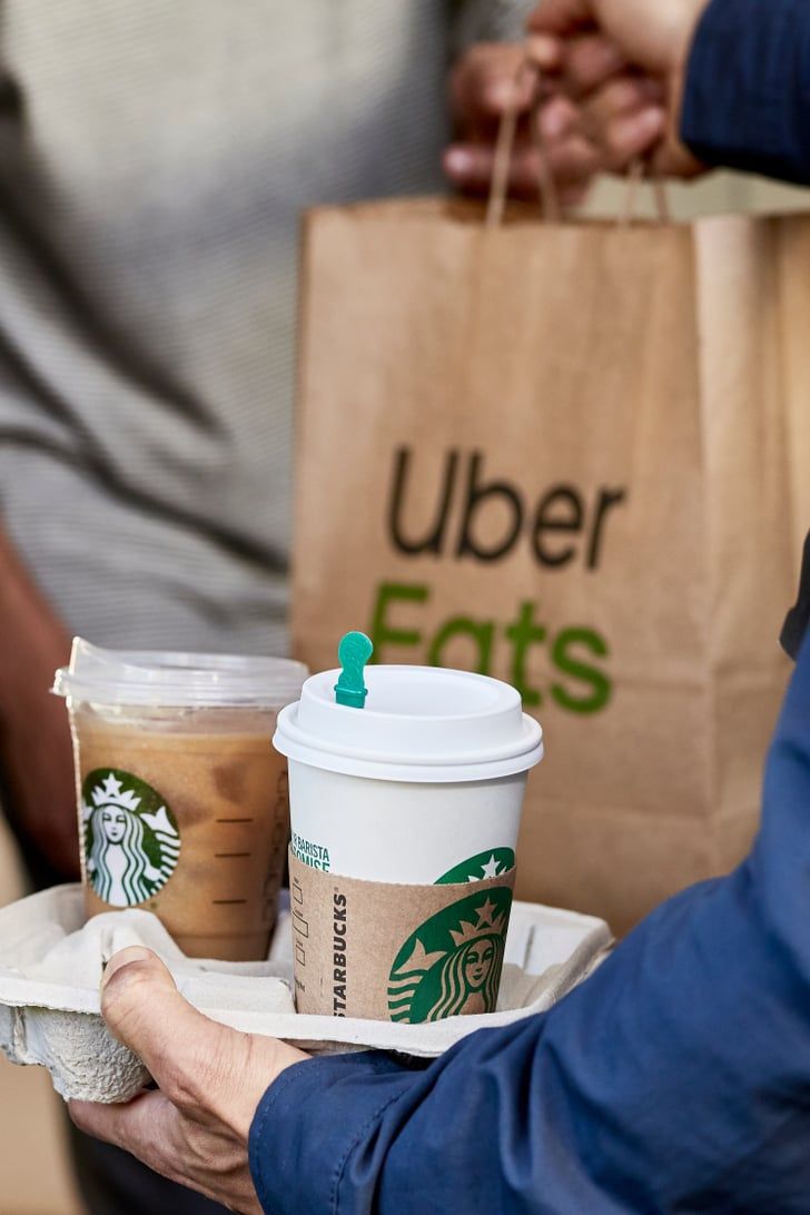 two people holding starbucks coffees in their hands and paper bags on the other hand