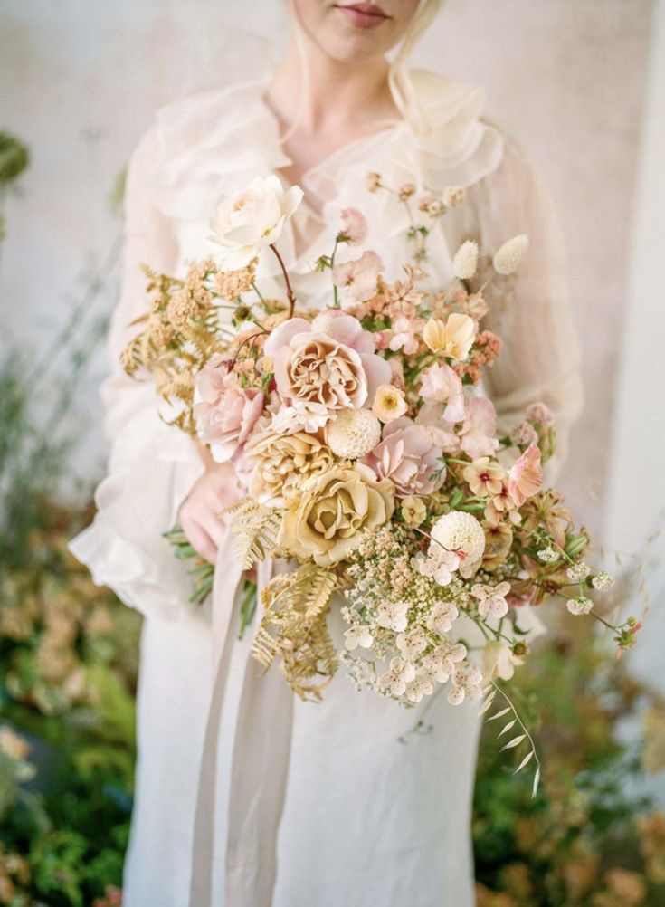 a woman holding a bouquet of flowers in her hands