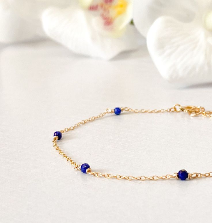 This beautifully simple bracelet is lovingly handmade with a six tiny Lapis Lazuli gemstones and a choice of 14k Gold Filled, 14k Rose Gold Filled or Sterling Silver Chain. M A T E R I A L S: * Lapis Lazuli * 14k Gold Filled, 14k Rose Gold Filled or Sterling Silver Chain S I Z E: *  Gemstones - Approximately 2-3mm *  Chain Thickness - Approximately 1.1mm  All of our jewellery is carefully handmade using good quality materials and handpicked gemstones, with the aim to produce quality pieces that you can love & wear for years to come.  L A P I S  L A Z U L I: * September Birthstone * Talisman for Taurus, Virgo, Libra, Sagittarius * Throat Chakra, Third Eye Chakra A stone of protection, Lapis Lazuli quickly releases stress, bringing deep peace. It brings harmony and deep inner self-knowledge.