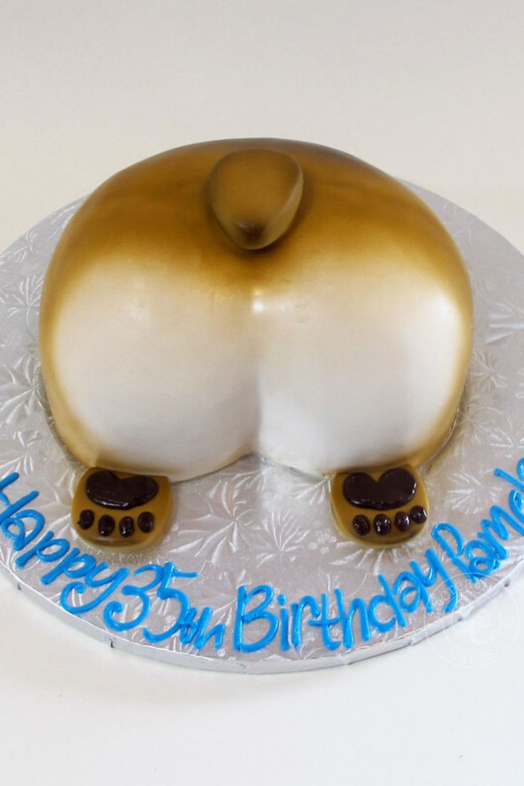 a white and gold birthday cake with an animal on it's head, sitting on top of a plate