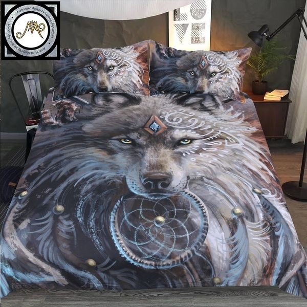 a bed with two wolfs on it and one has a dream catcher in its mouth