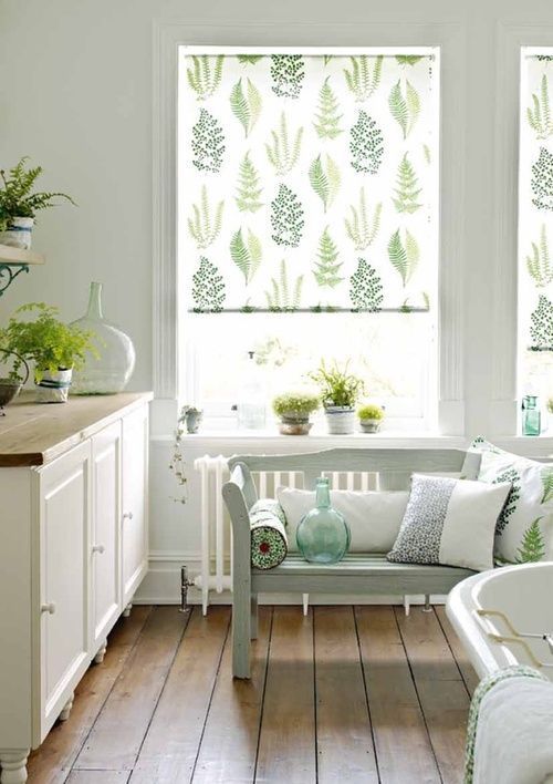 a bath room with a tub a sink and some plants in the window sill