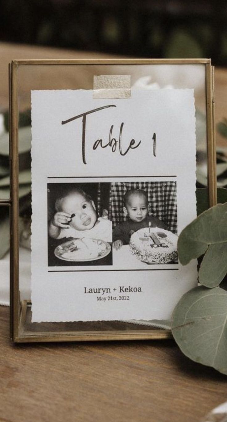 a table that has some pictures on it and leaves in front of it, along with other place settings