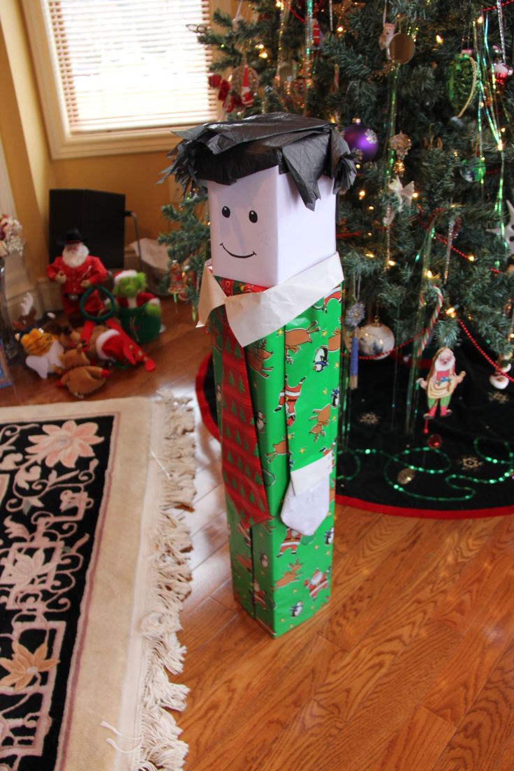 a christmas tree is in the background with presents under it and a paper bag that looks like a nutcracker