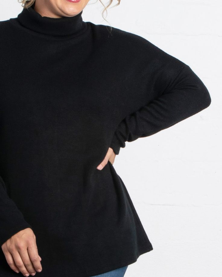 Wear this plus-size turtleneck as a top layer or alone, depending on your cold-weather needs. Funnel Neck Turtleneck For Layering, Oversized Turtleneck For Layering, Black Fine Knit High Neck Top, Black Fine Knit Funnel Neck Top, Oversized Fine Knit Turtleneck Top, Soft Knit Funnel Neck Tops For Work, Relaxed Fit Soft Knit Funnel Neck Top, Black Soft Knit Turtleneck Top, Oversized Turtleneck Top For Work