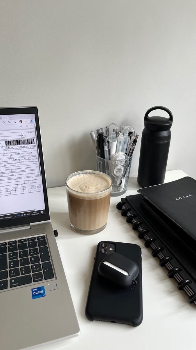 an open laptop computer sitting on top of a desk next to a cup of coffee