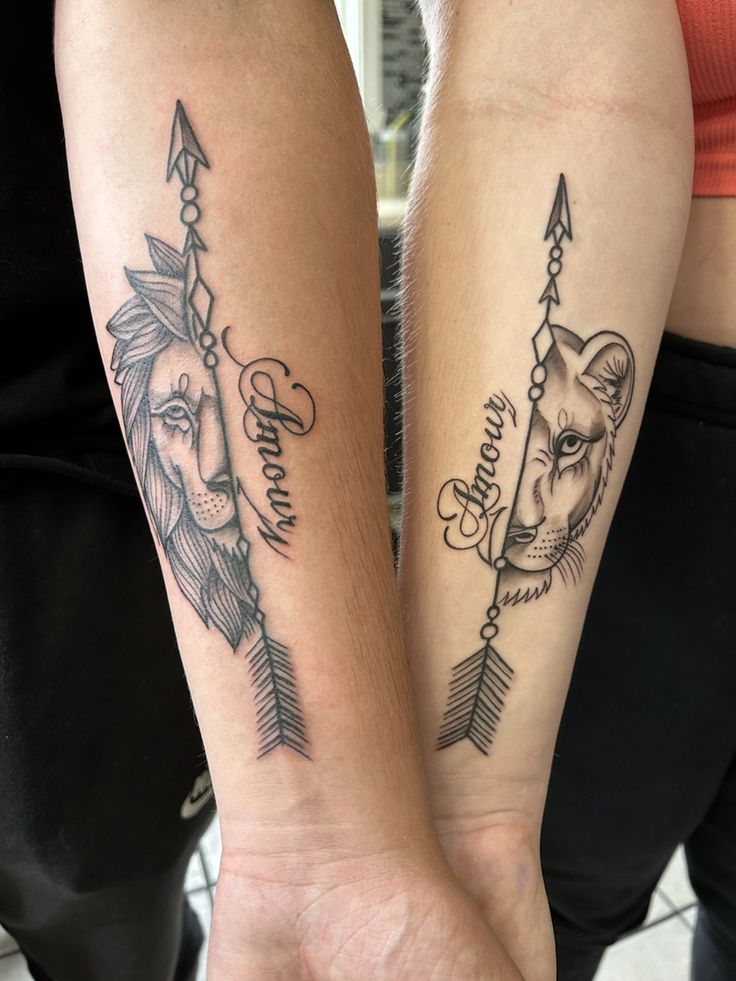 two people holding hands with tattoos on their arms, one has a lion and the other has an arrow