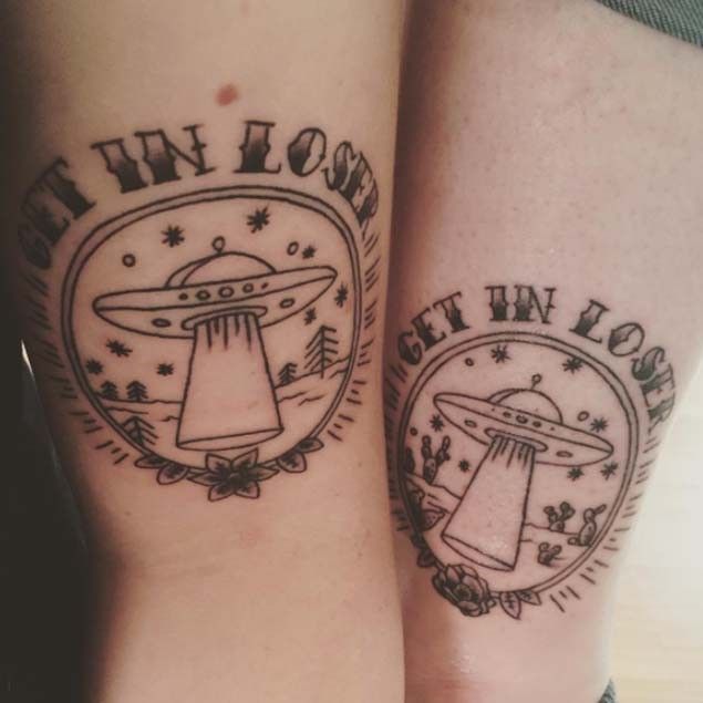 two tattoos on both legs with the words i'm in love and an alien ship