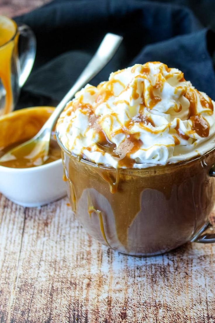 there is a cup of hot chocolate with whipped cream and caramel on the top