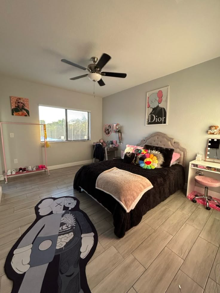 a bedroom with a bed, desk and ceiling fan