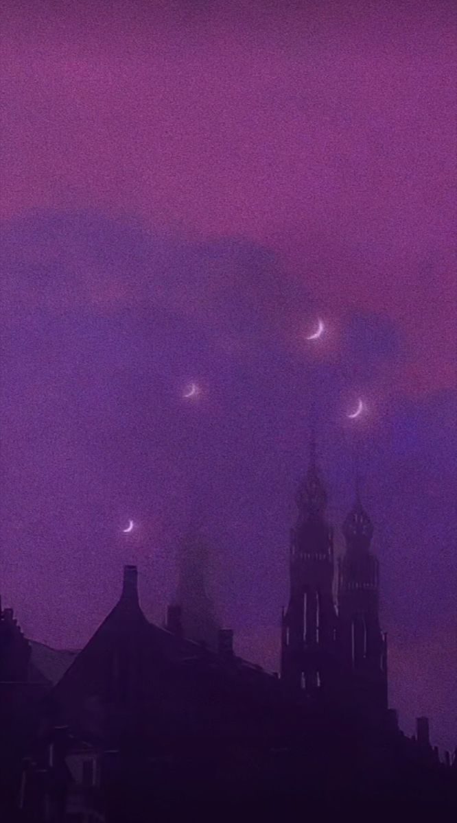 the sky is purple and there are many stars in the night sky above buildings with clocks on them