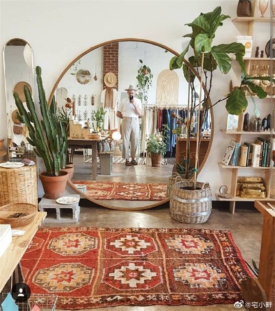 a room filled with lots of plants and rugs on top of wooden flooring