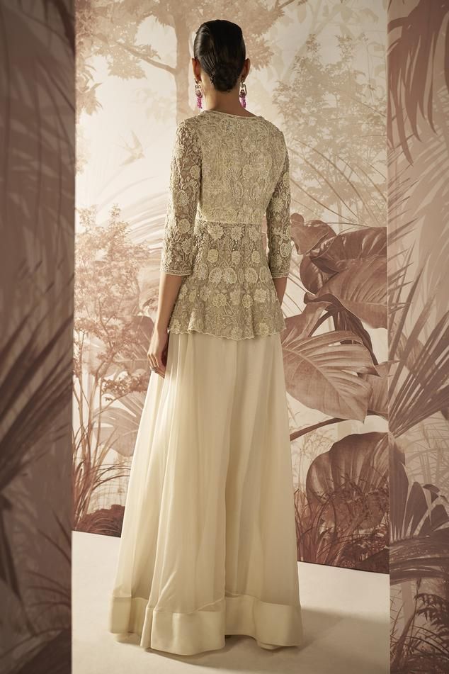 Ivory peplum with pearl and crystal embroidered floral jaal motifs. Comes with sharara.
Components: 2
Pattern: Embroidered
Type Of Work: Sequin,Pearl
Neckline: V-neck
Sleeve Type: Three quarter 
Fabric: Peplum: Net, Sharara: Organza
Color: Ivory
Other Details: 
Empire waist
Closure: Peplum: Front closure
Occasion: Cocktail,Reception,Sangeet - Aza Fashions Elegant Off White Gown With Intricate Embroidery, Elegant Evening Sets With Peplum Shape, Elegant Cream Gown With Intricate Embroidery, Elegant Off White Gown For Reception, Elegant Off White Festive Gown, Elegant Off-white Festive Gown, Elegant V-neck Festive Set, Elegant Beige Wedding Sets, Intricate Embroidery Mother Of The Bride Dress For Wedding