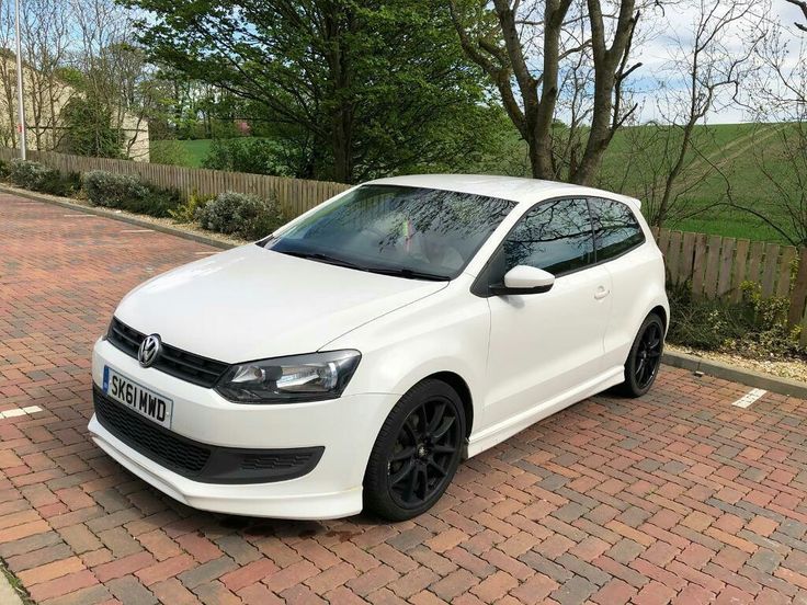 a white car parked on the side of a brick road