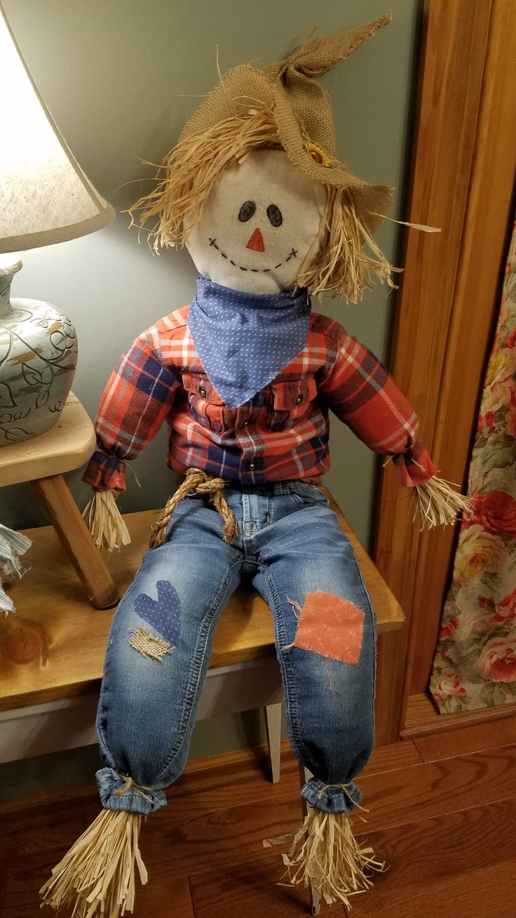 a scarecrow doll sitting on top of a wooden table