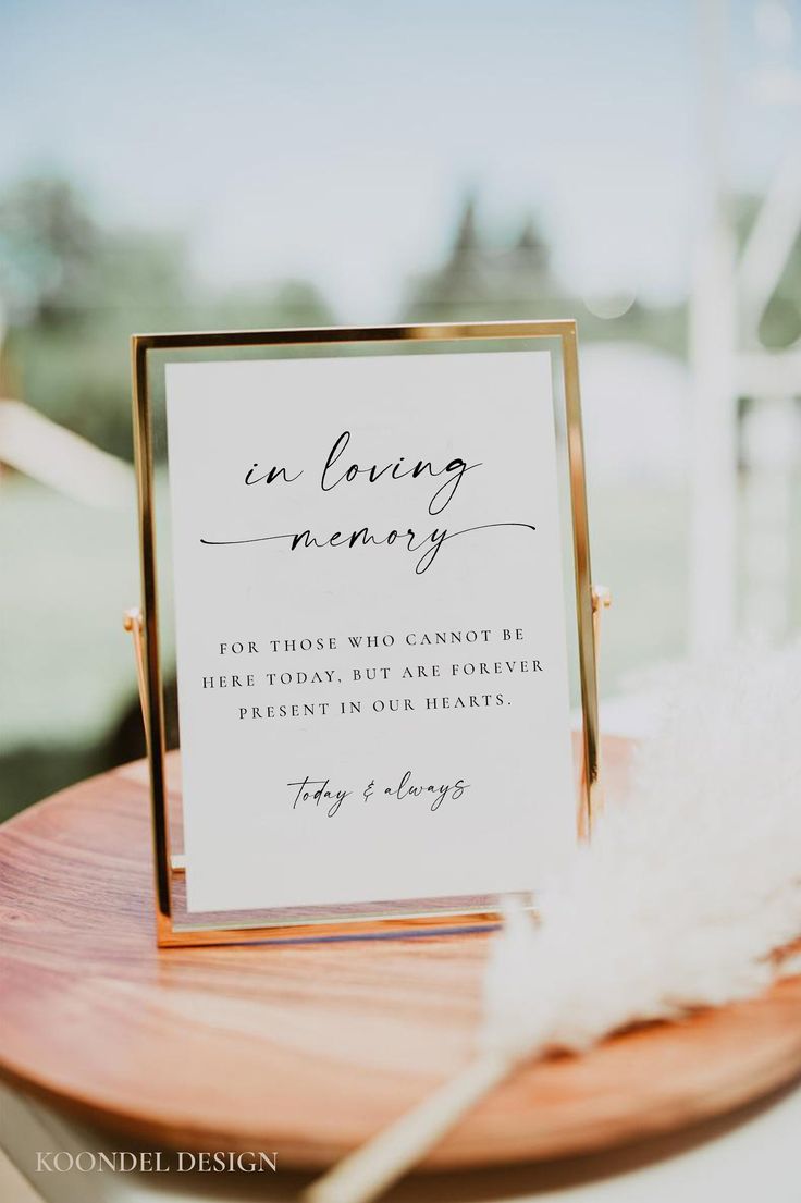 a close up of a sign on a table with a white feather in front of it