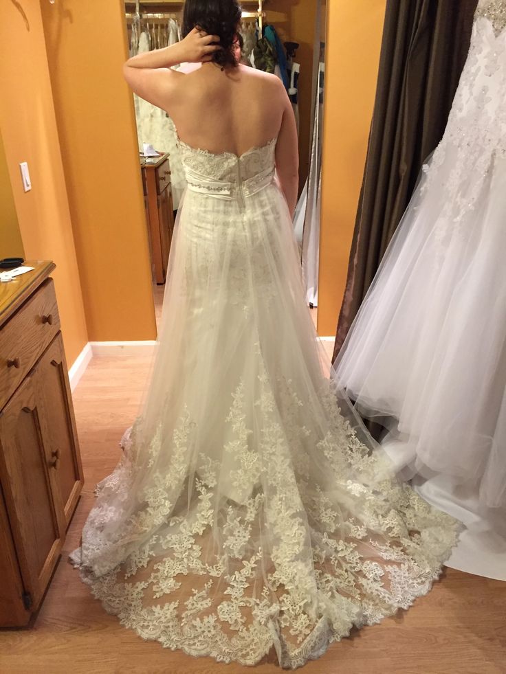 a woman is looking at her wedding dress in the mirror