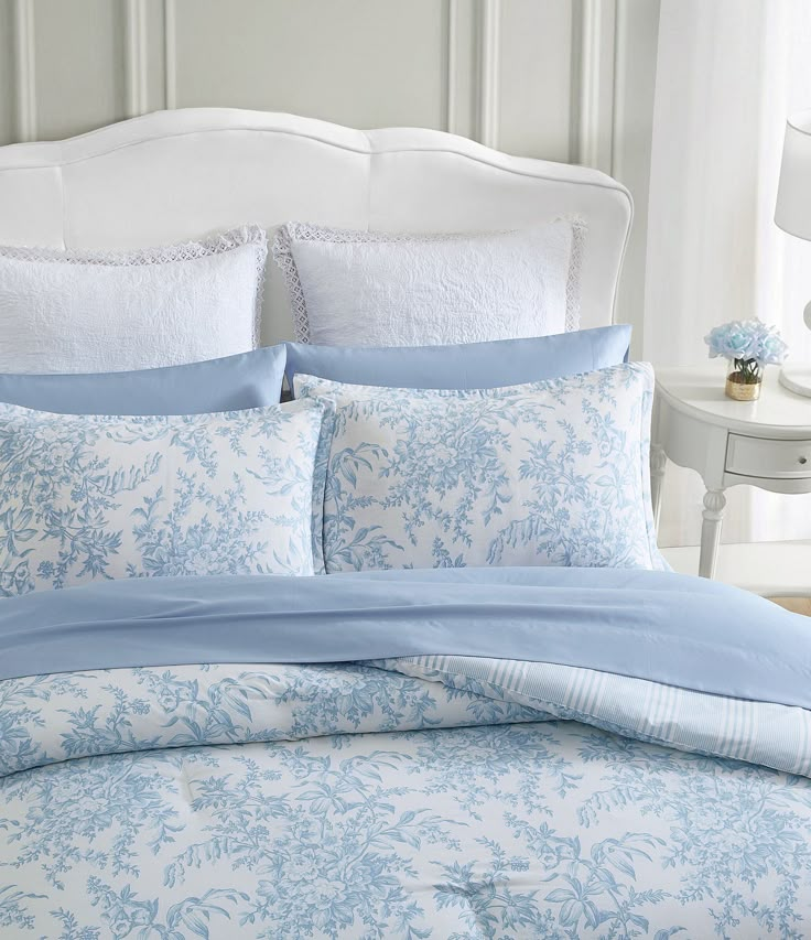 a bed with blue and white comforters in a bedroom