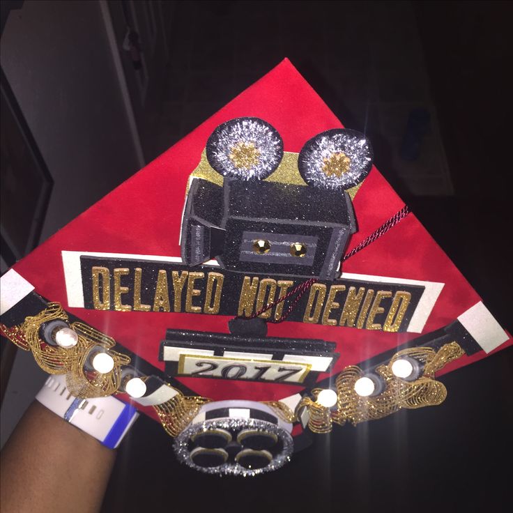 a red and gold graduation cap with the words, delivered not opened on it's side