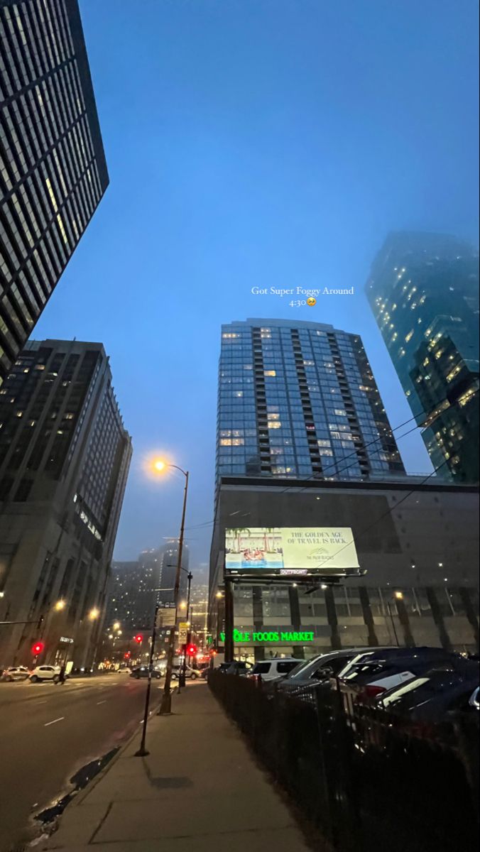 an empty city street with tall buildings in the background