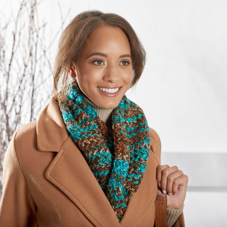 a woman wearing a brown coat and blue scarf