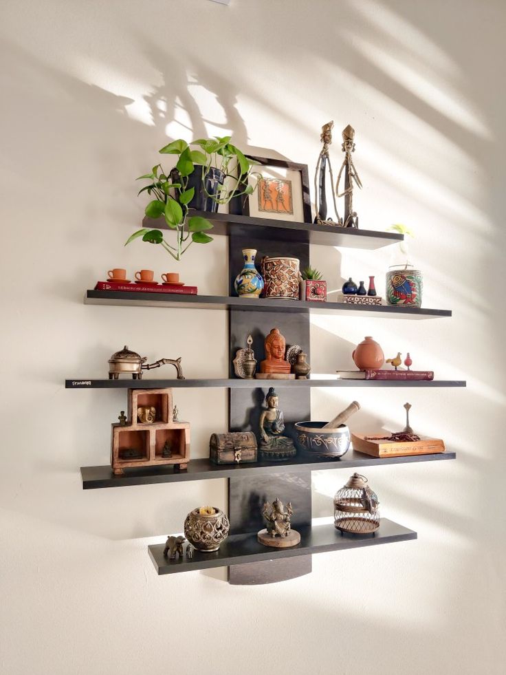 several shelves with pots, vases and other items on them in a white room