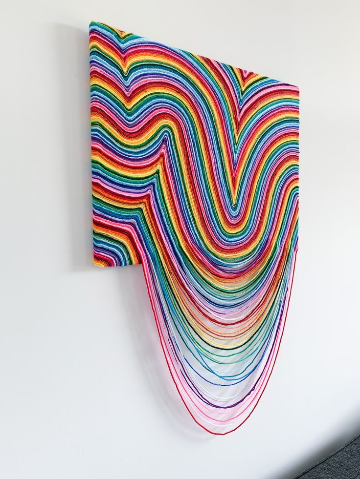 a multicolored art piece hanging on the wall