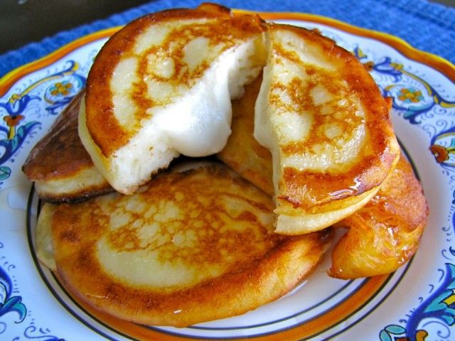 pancakes with butter and syrup are on a blue and orange plate, ready to be eaten