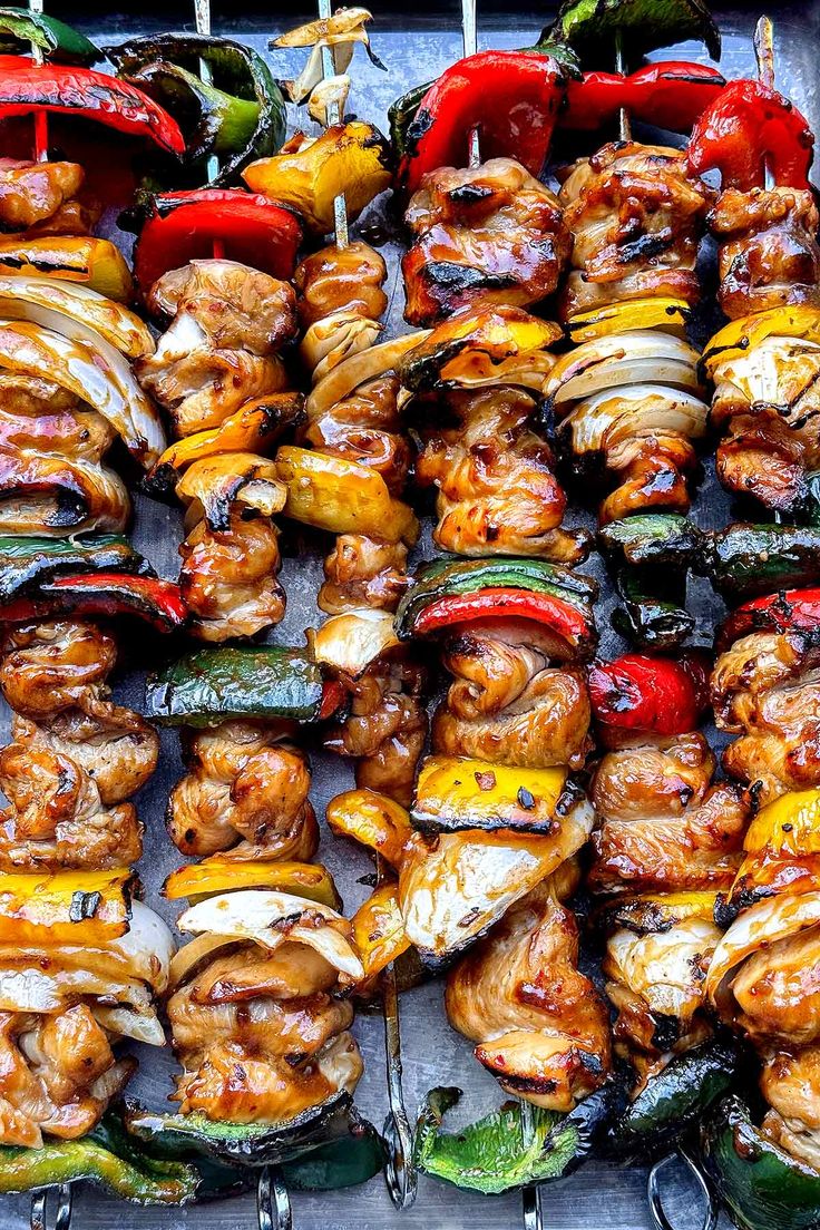 several skewers of meat and vegetables are being grilled