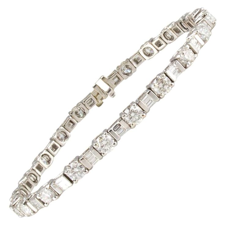 These illuminating round and baguette diamonds that are featured in this bracelet are nothing short of stunning. This gorgeous bracelet has 5.15 carat total round brilliant diamonds. Their beauty is further enhanced by sparkling 1.35 carat total baguette diamonds that are bar set into the sleek 14 Karat white gold mounting. If you want to elevate the classic tennis bracelet, set yourself apart from this contrast-faceted combination of shapes. Emerald Bracelet Gold, Bracelet Tennis, Emerald Bracelet, Gold Armband, Diamond Jewelry Designs, Baguette Diamonds, White Gold Bracelet, Unique Diamonds, Women Diamond