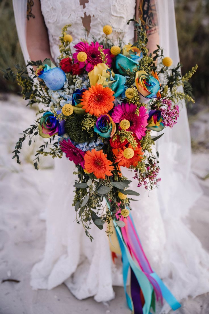 a bride holding a colorful bouquet in her hand