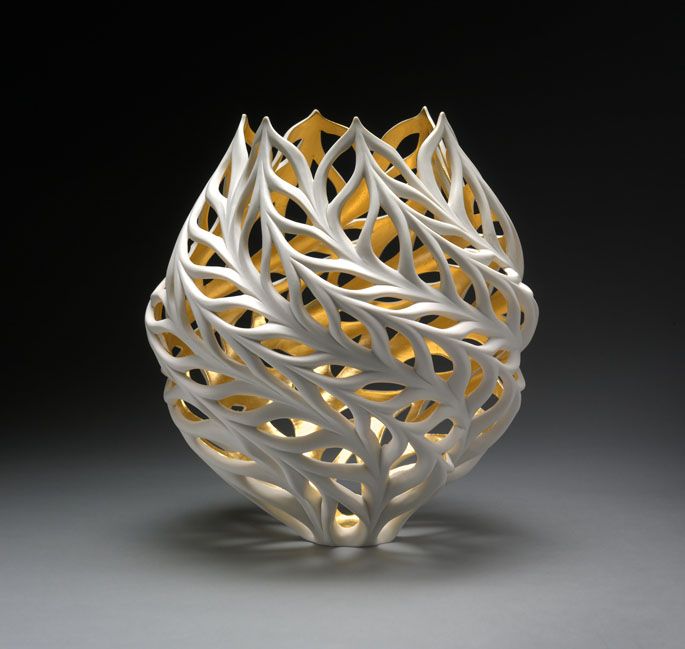 a white and yellow sculpture on a gray surface with light coming from it's center