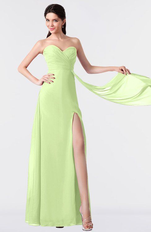 a woman in a lime green dress posing with her hand on her hip and wearing a high slit skirt