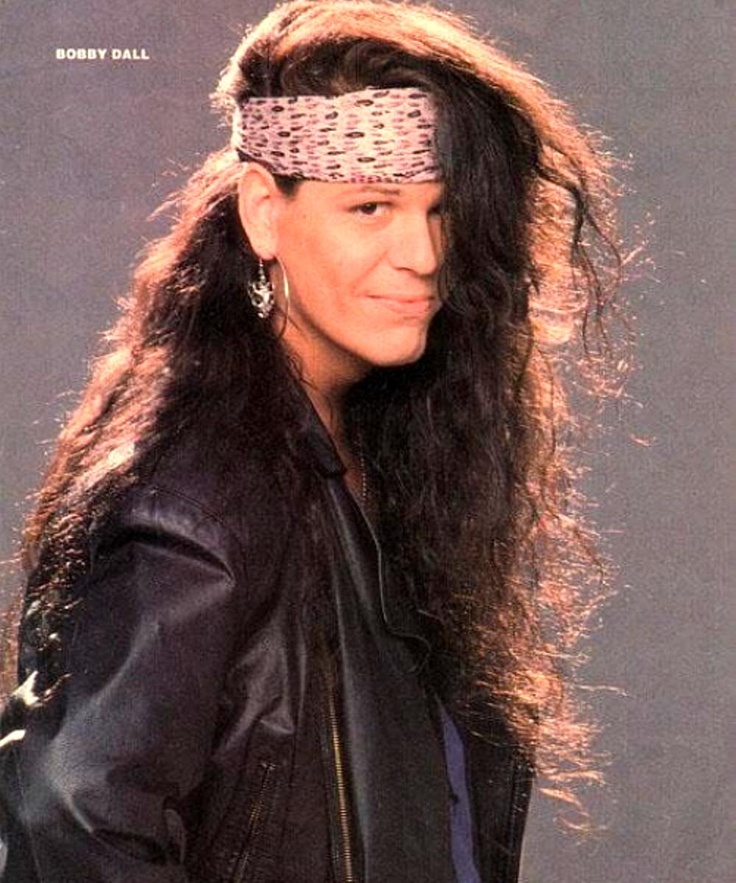 a woman with long hair wearing a leather jacket and headband, posing for the camera