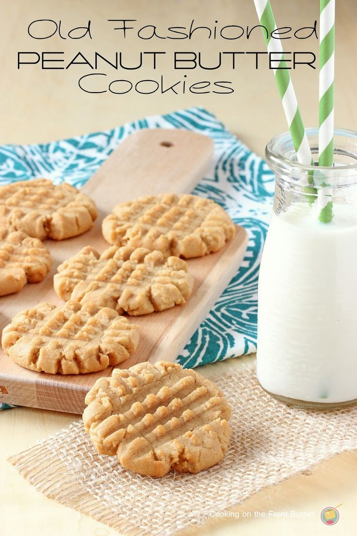 some cookies are on a wooden board next to a glass of milk