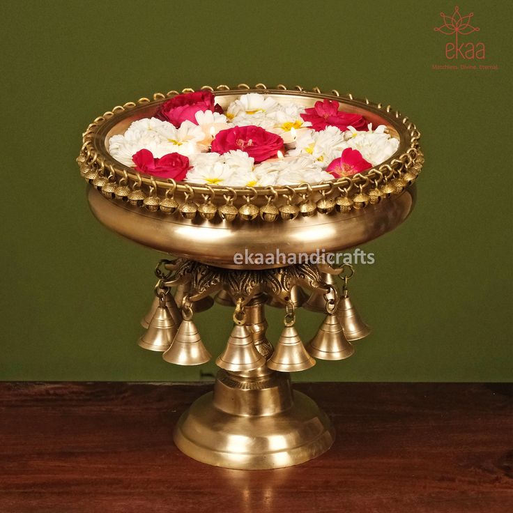 a brass plate with flowers in it on a table