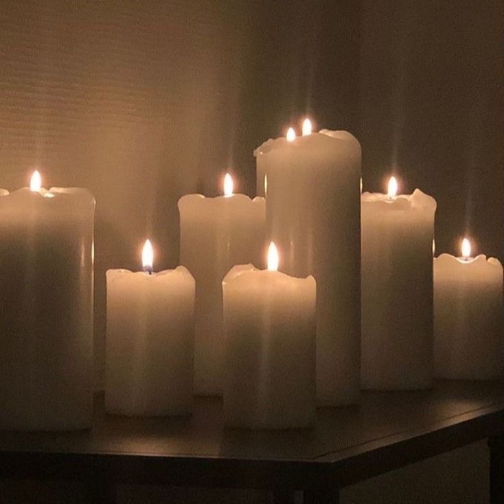 many lit candles sitting on top of a table