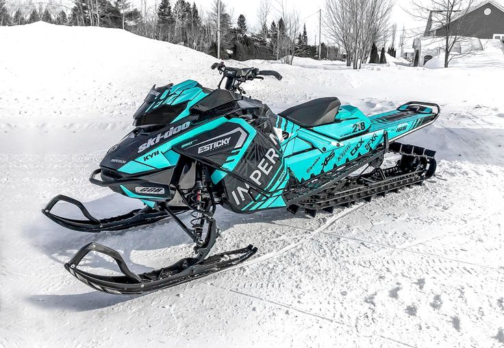 a blue snowmobile parked in the snow