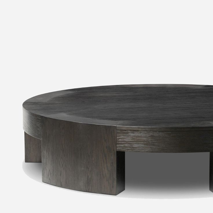 a round wooden table sitting on top of a white floor