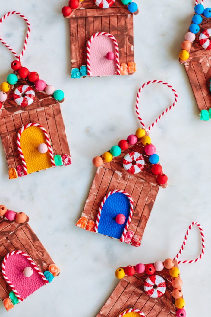 homemade gingerbread house ornaments with candy and candies hanging from the front on a marble surface