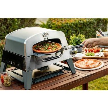 a pizza is being cooked on an outdoor grill