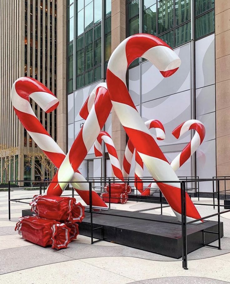 large red and white candy canes on display in front of building