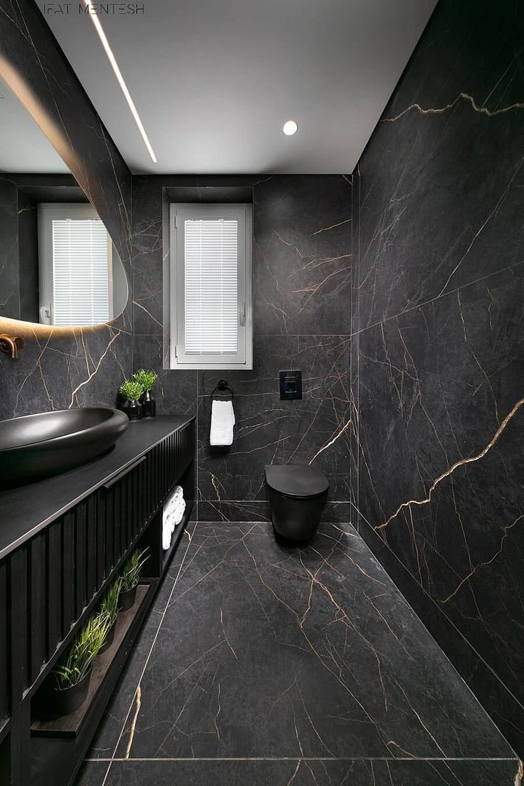 a bathroom with black marble walls and flooring