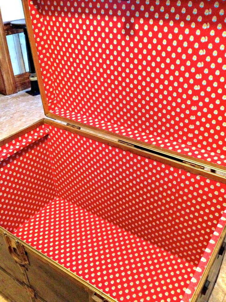 an open suitcase sitting on top of a hard wood floor covered in red and white polka dots