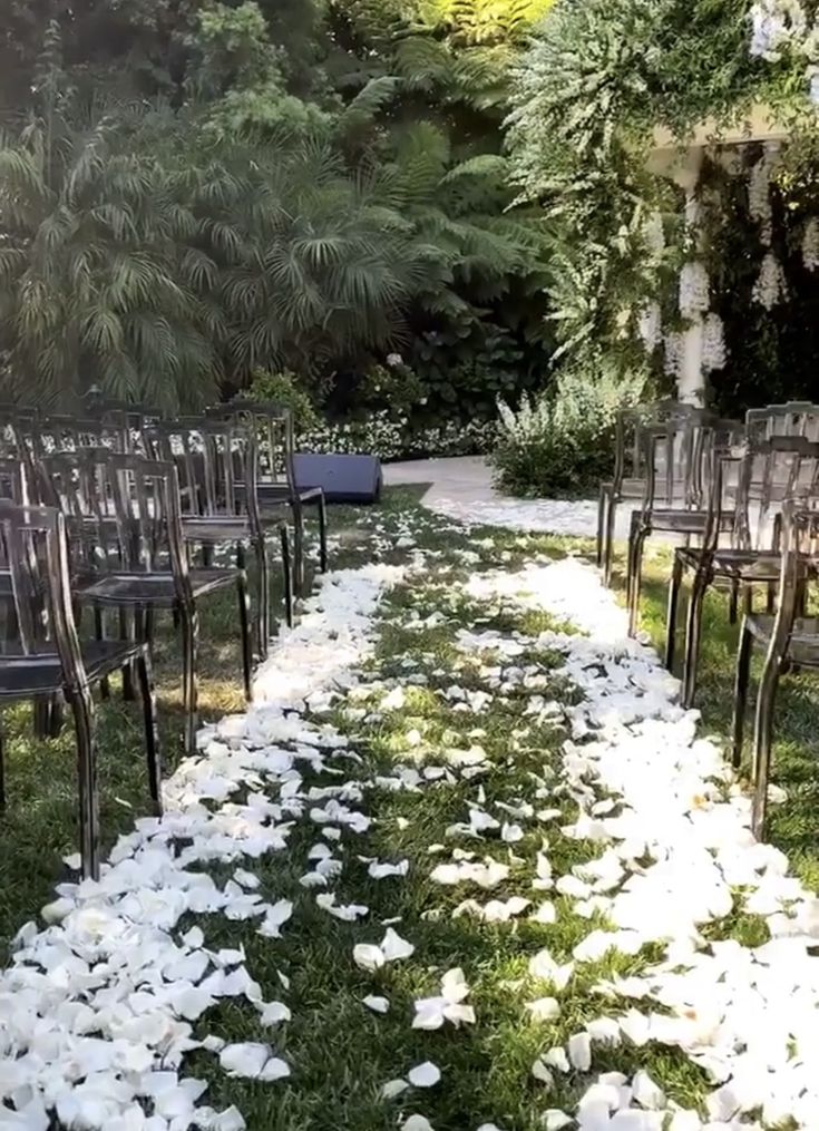 rows of chairs with white flowers on the grass