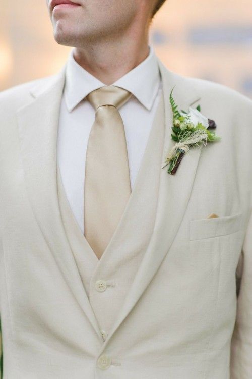 a man wearing a suit and tie with a boutonniere on his lapel